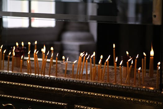 Lit candles in an indoor religious setting in Istanbul, creating a warm and spiritual atmosphere.
