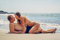 一对夫妇在阳光明媚的海滩上享受浪漫时刻，象征着爱与亲密