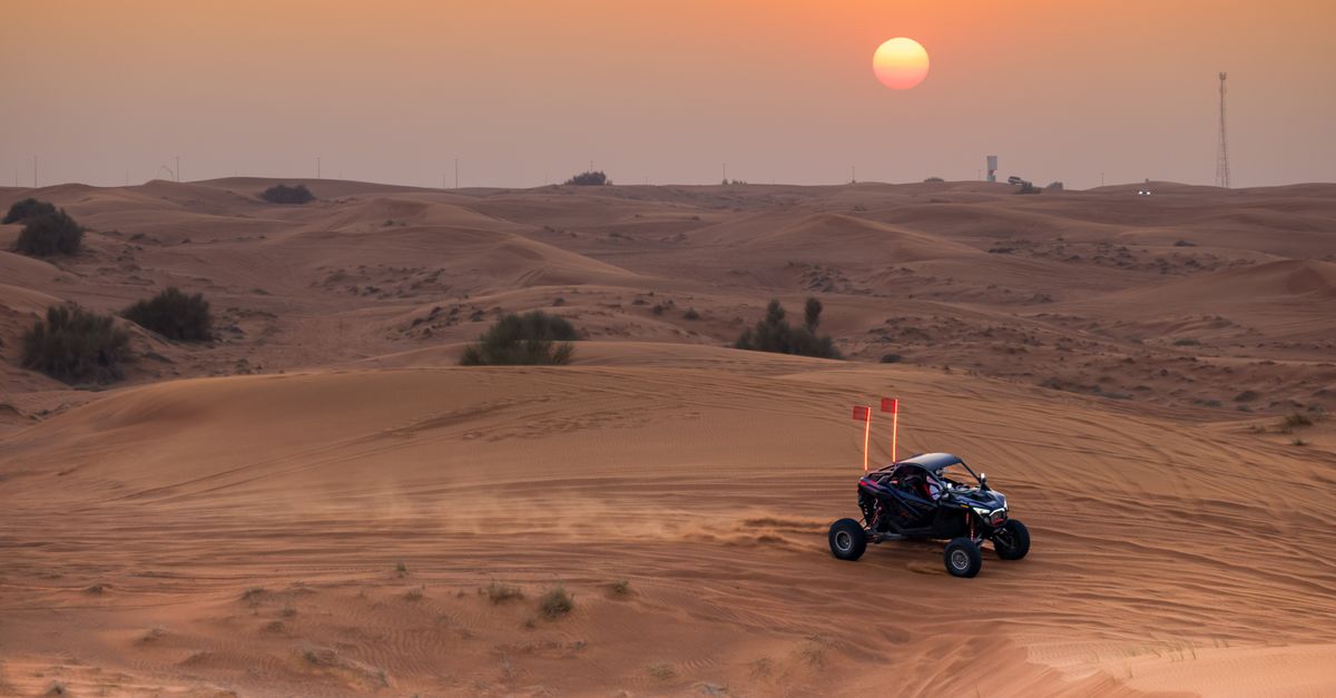 Dune buggy ride across desert dunes at sunset, highlighting adventure and nature.