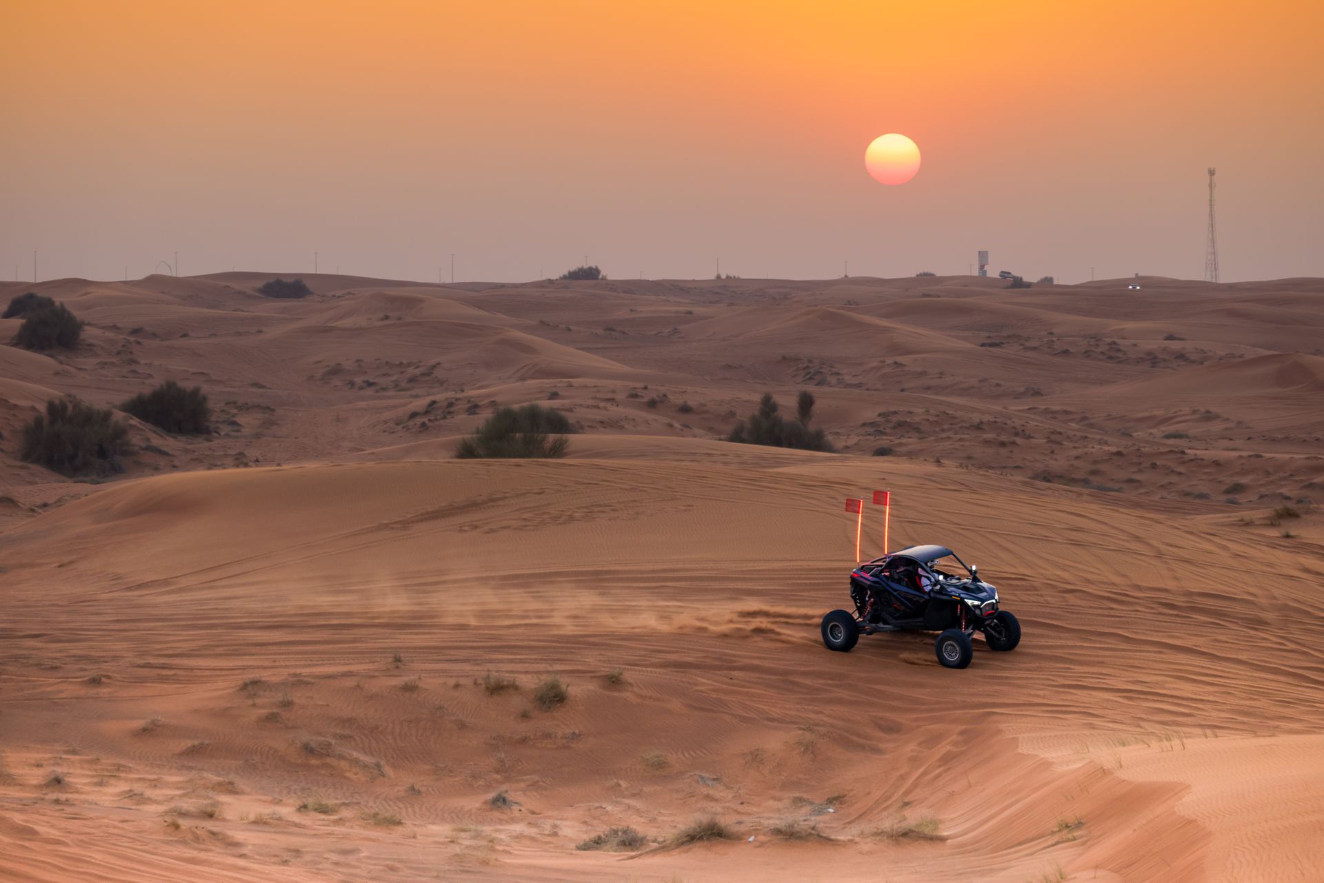 Dune buggy ride across desert dunes at sunset, highlighting adventure and nature.