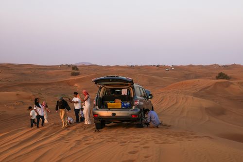 Free A group enjoying a scenic Sahara desert adventure with a 4x4 vehicle. Stock Photo