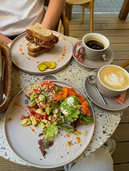 Delicious brunch featuring gourmet salmon salad and fresh sandwiches, paired with coffee. Perfect for a cozy morning.