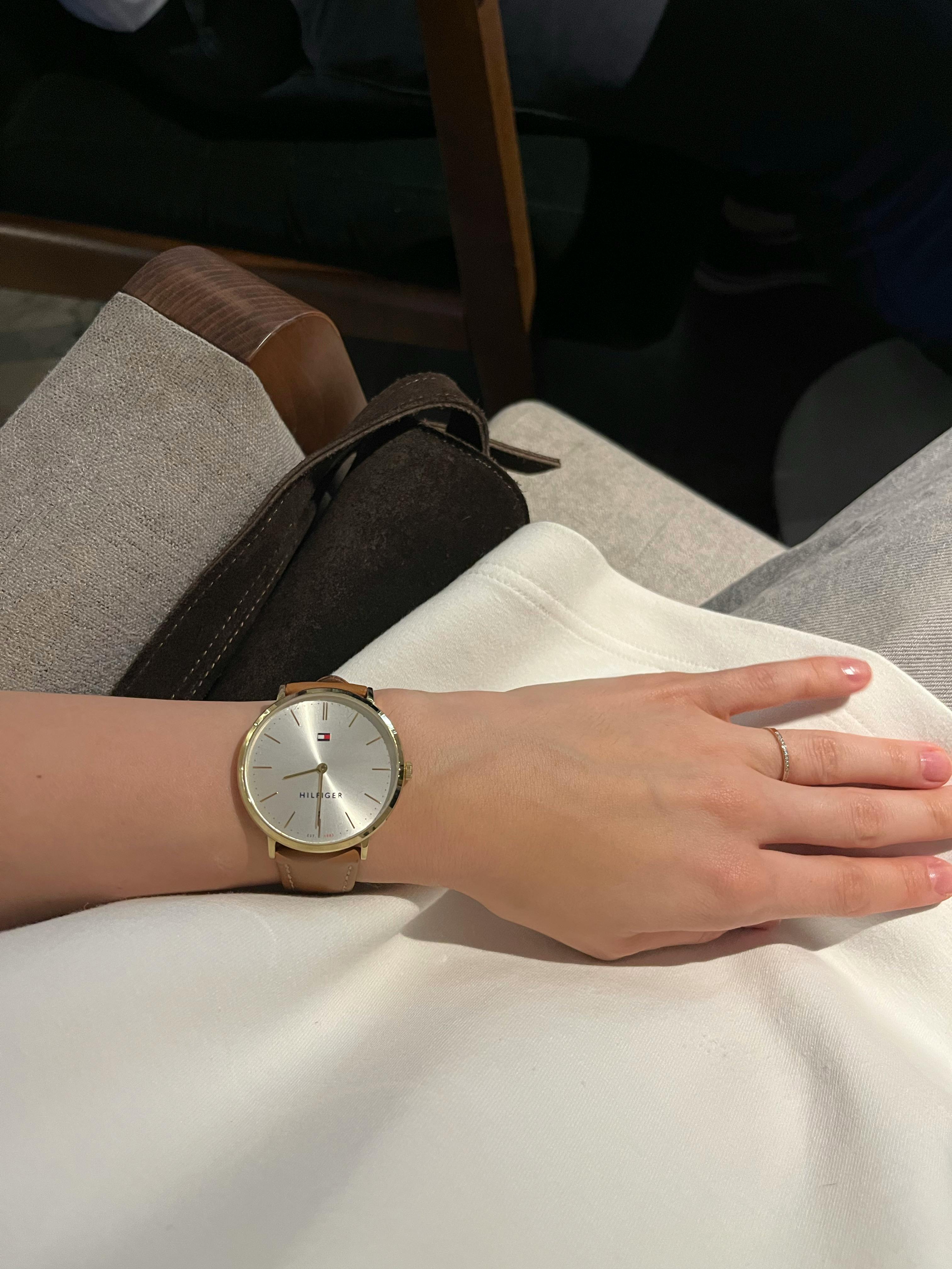 Close-up of a minimalist silver wristwatch on a woman's wrist, showcasing modern elegance.