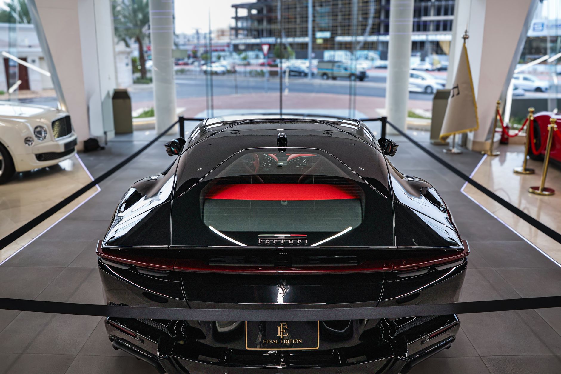 High-end black sports car displayed in a luxurious showroom with modern design elements.