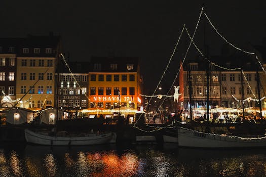 Captivating night scene of Nyhavn Copenhagen with festive lights reflecting on the water.