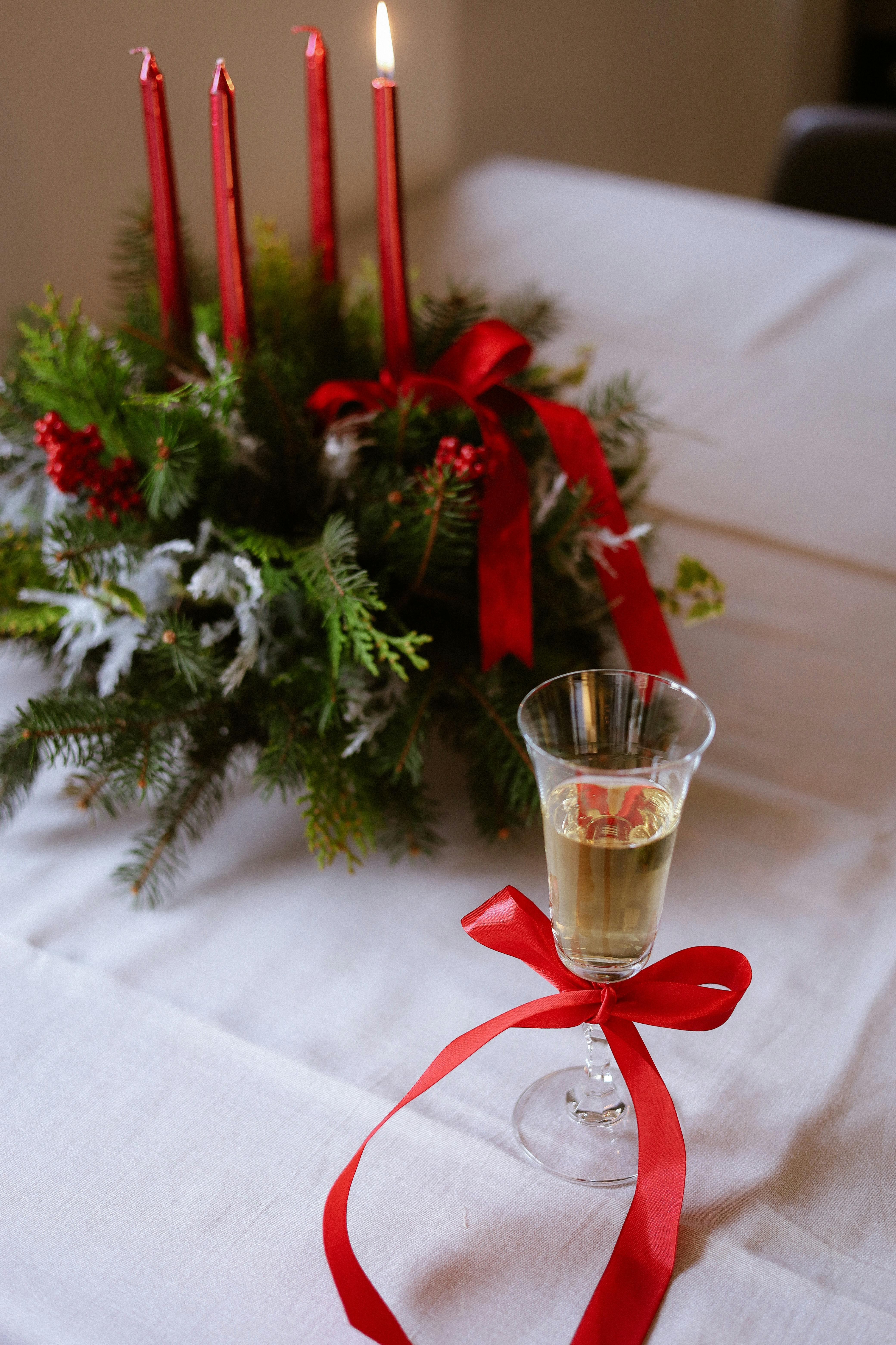 Elegant Christmas table setting with candles and champagne glass, perfect for holiday celebrations.