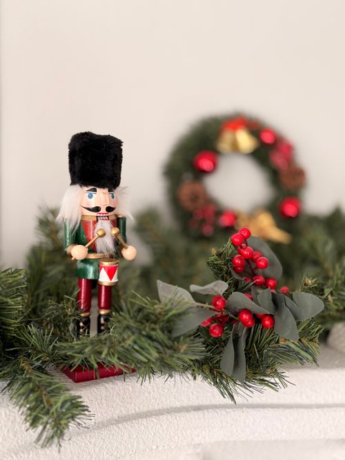 Free Nutcracker and Christmas wreath with greenery indoors Stock Photo
