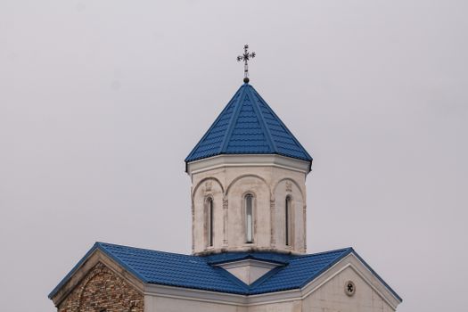Photo of a church dome with a blue roof and cross in Kutaisi, Georgia.