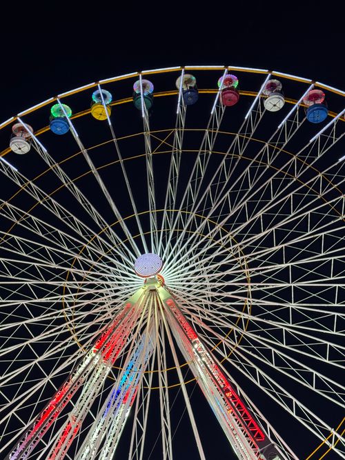Free Colorful Ferris wheel glowing against night sky, capturing a festive carnival ambiance. Stock Photo