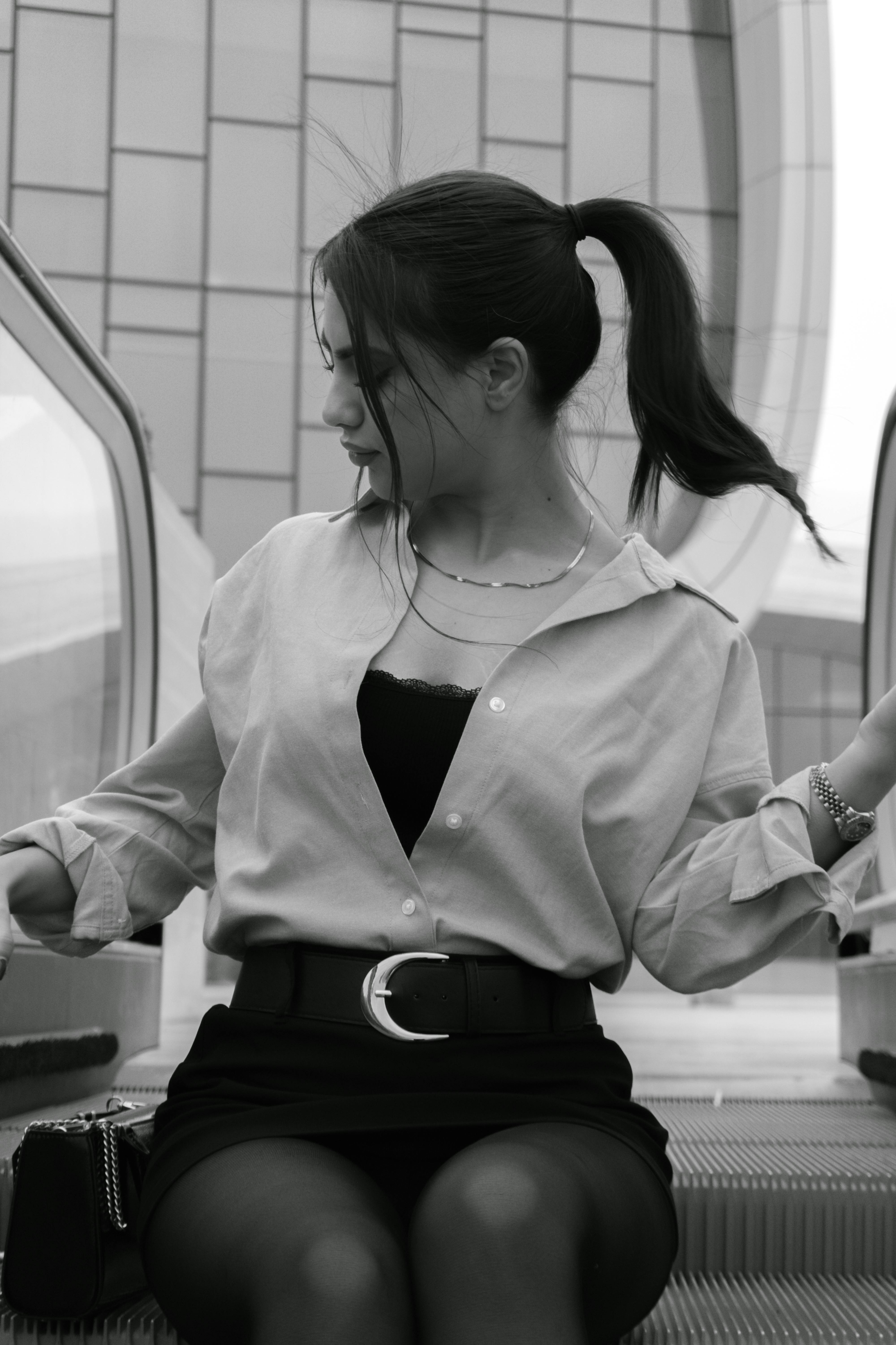 Gratis Elegant kvinne i moderne antrekk på en rulletrapp med urban arkitektonisk bakgrunn. Arkivbilde