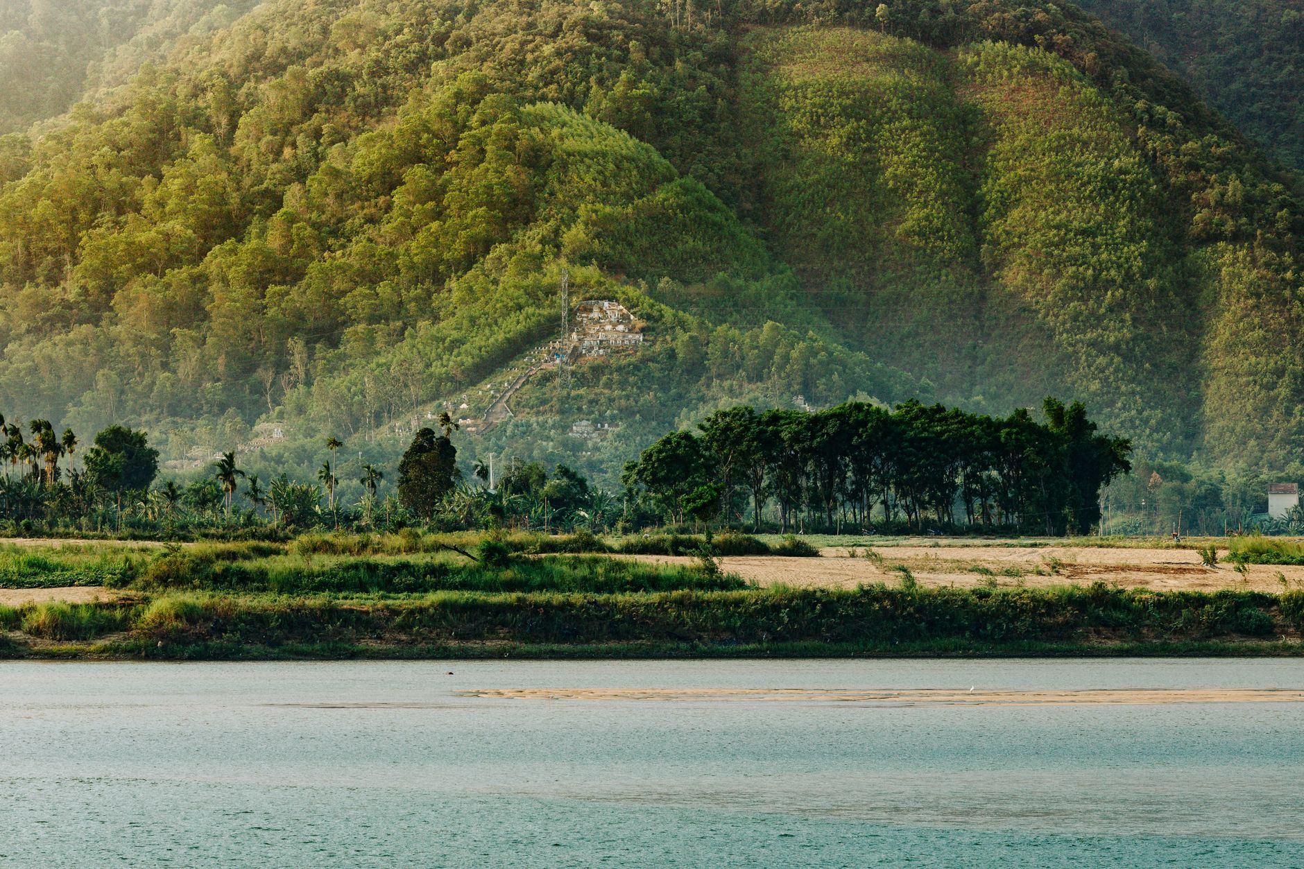 Peaceful view of lush green hills and a serene river in Da Nang, Vietnam.