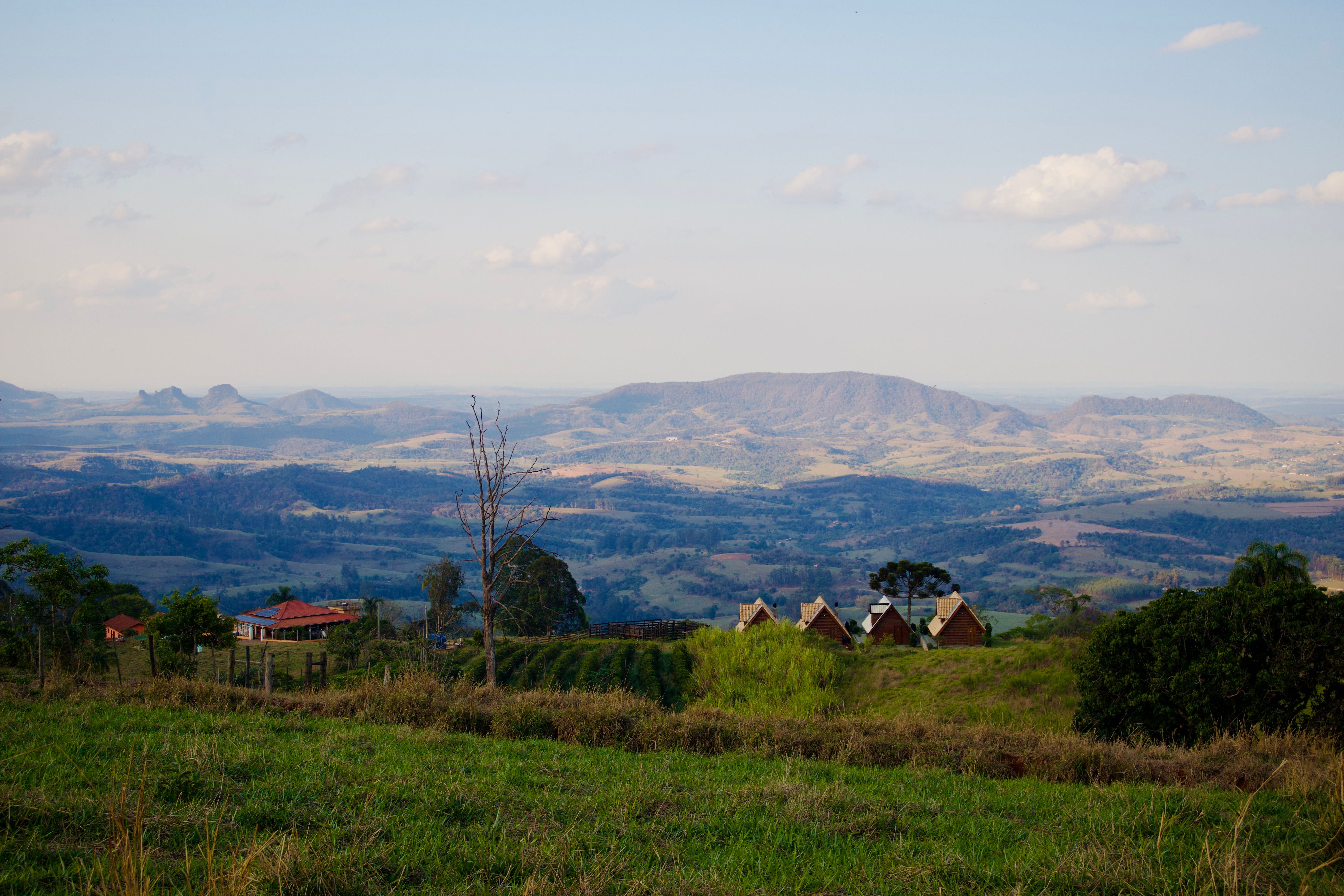 A scenic view of rolling green hills in Ho Volta Region with a small village in the distance