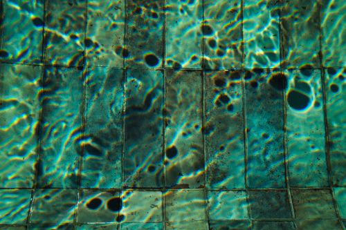 Free Vibrant abstract ripple patterns on water over pool tiles. Stock Photo