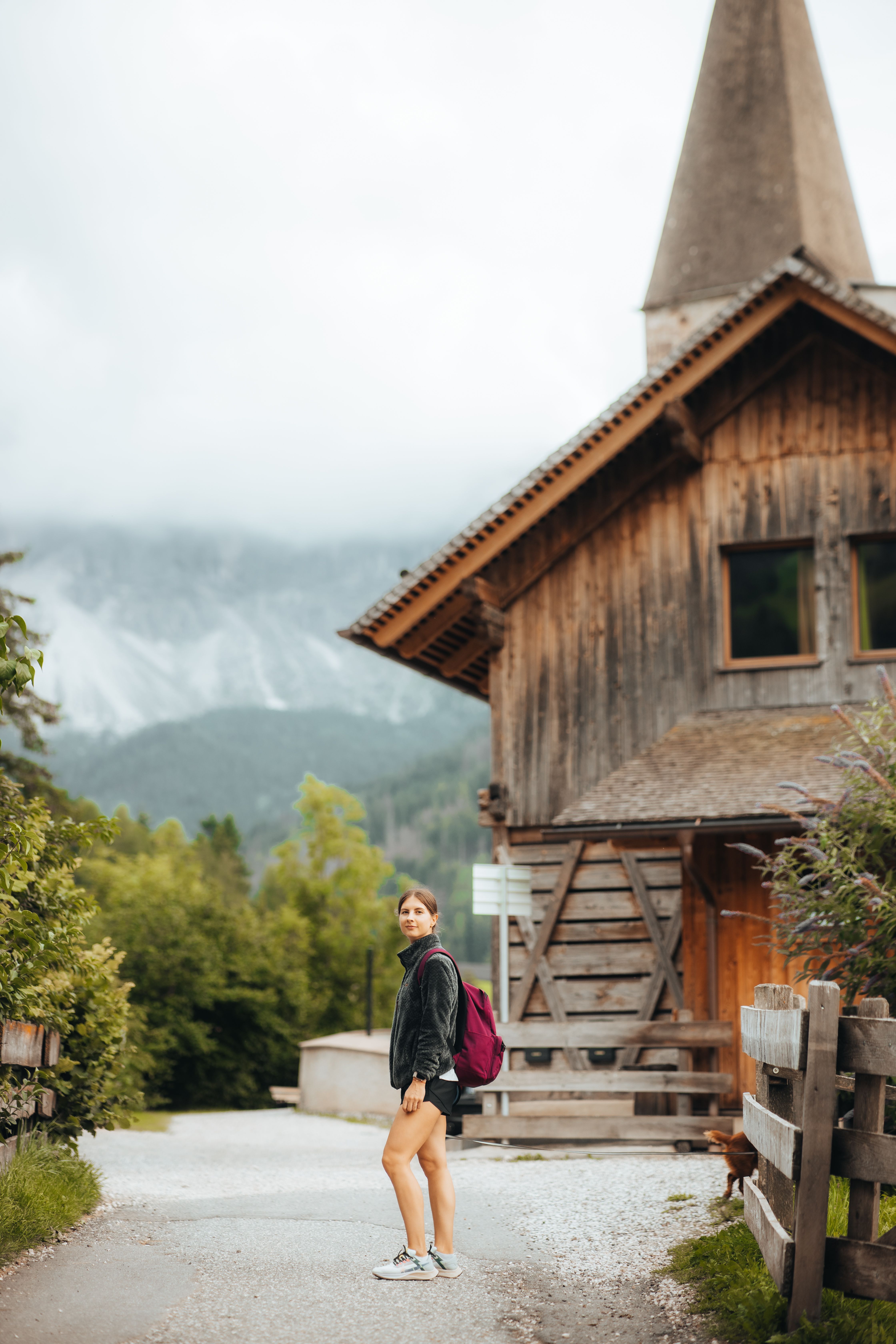 Young Woman Hiking by Rustic Mountain Cabin · Free Stock Photo
