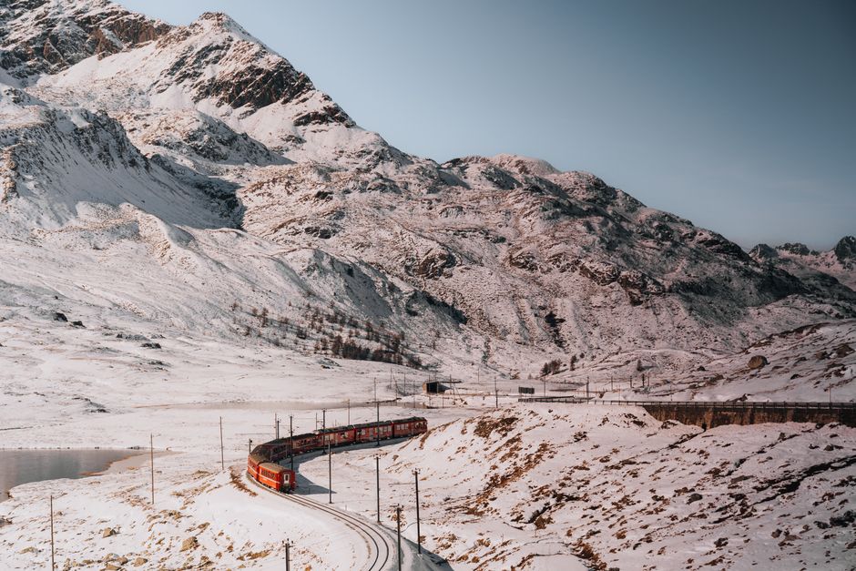 ÖBB Railjet train traveling through a picturesque valley in the Austrian Alps