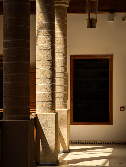 Sunlit stone columns casting long shadows — photo by Akram Ouahmane on Pexels
