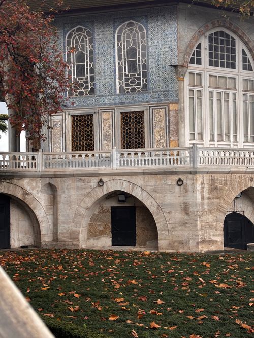 Free Elegant historic building with ornate windows surrounded by autumn leaves. Stock Photo