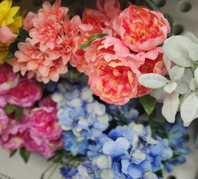 Colorful artificial flower bouquet showcasing pink, blue, and white hues.