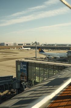 A bustling airport terminal with several airplanes ready for takeoff under a clear blue sky.