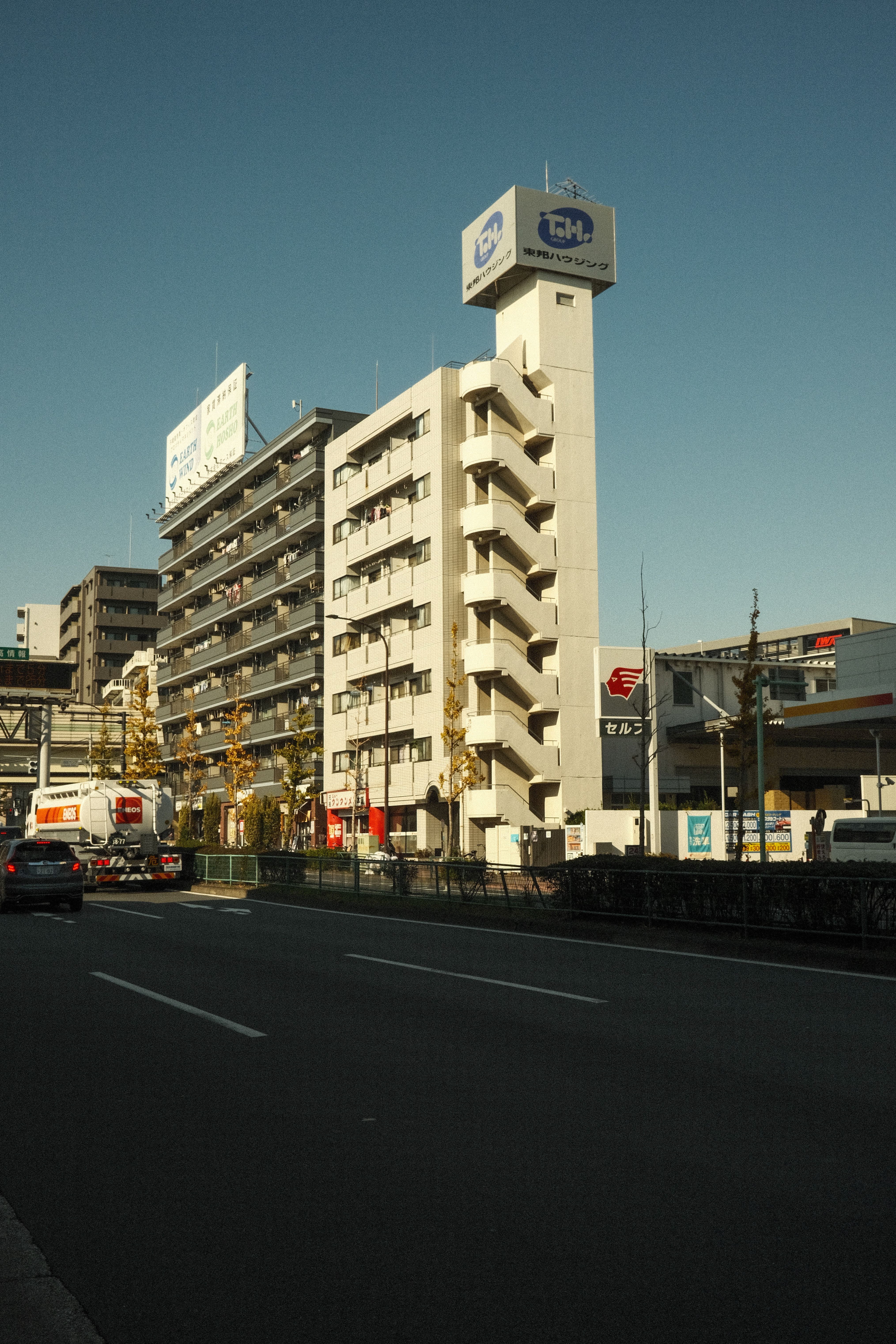 A view of modern buildings and a busy street in Tokyo, Japan, under a clear sky.