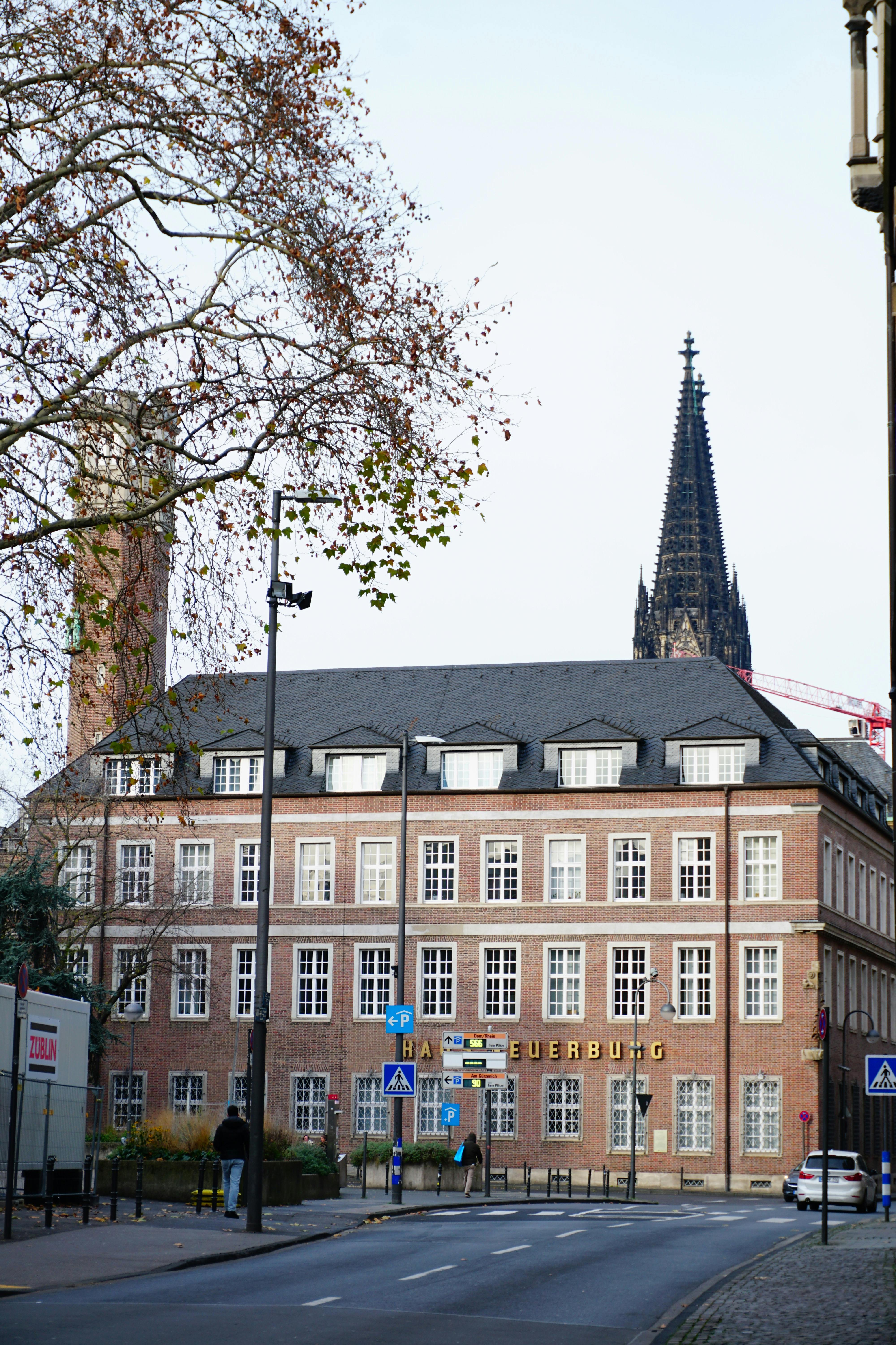 A striking urban scene featuring a historic building with a cathedral spire in the background.