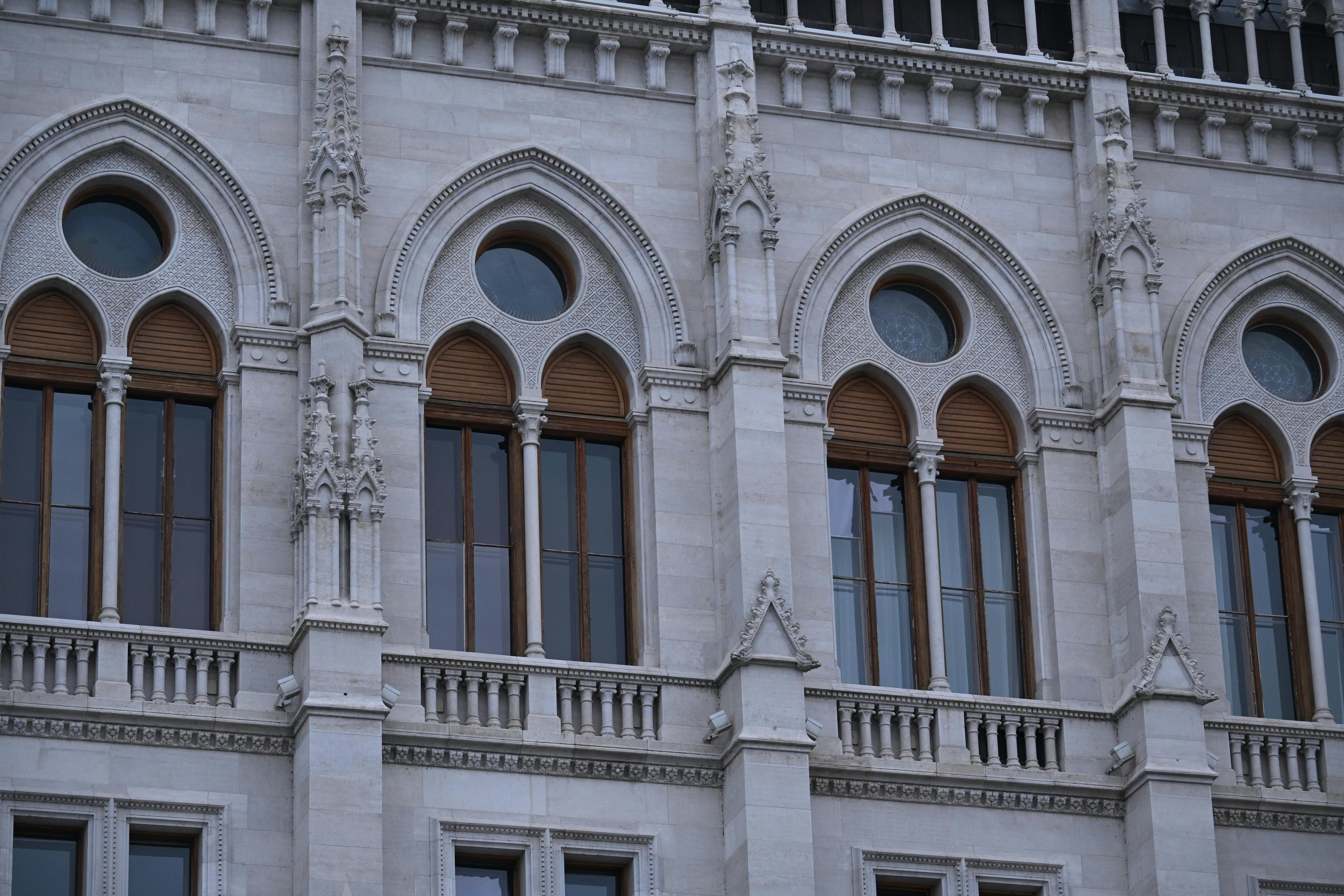Close-up of gothic style windows in an ornate historic building facade.
