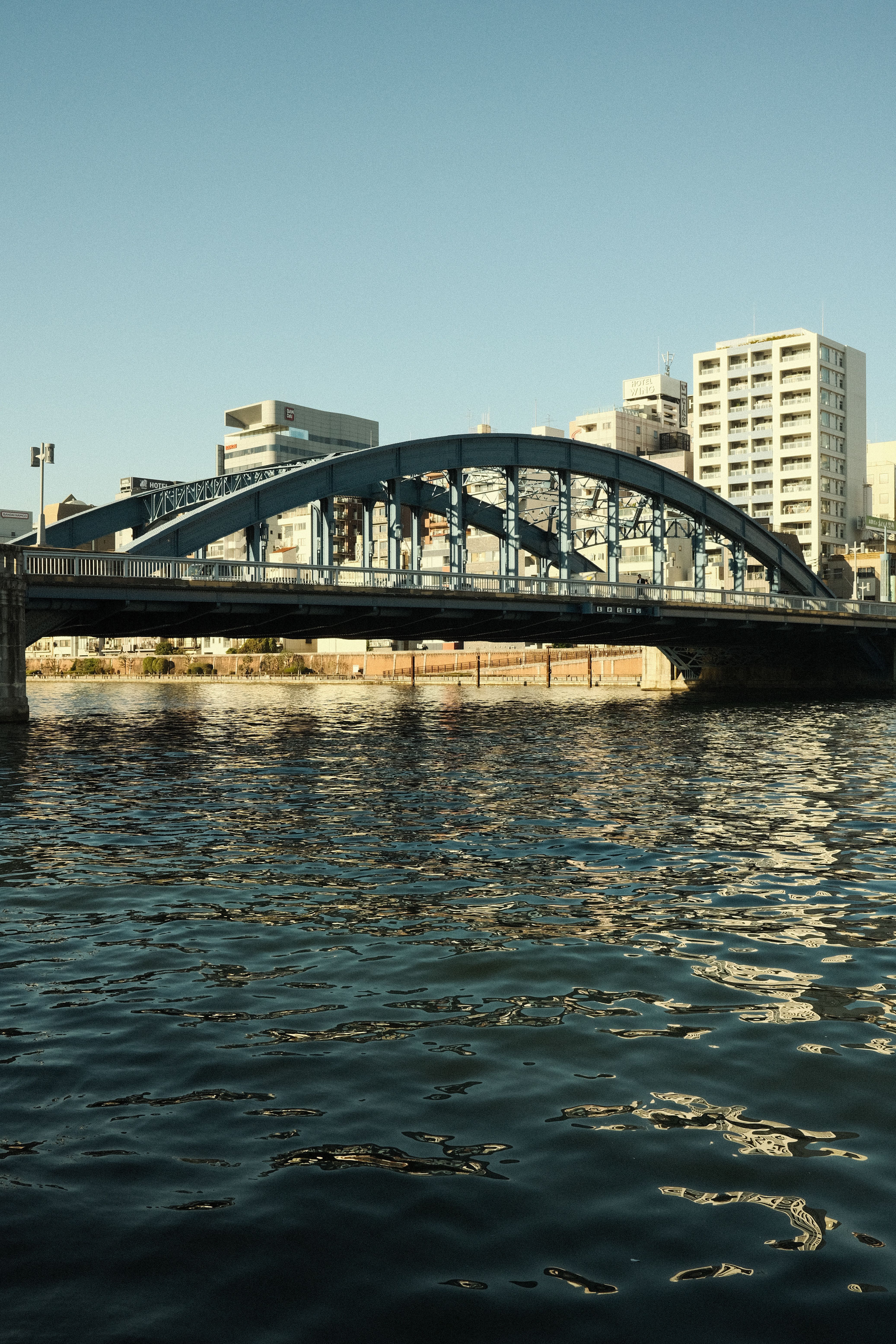 Scenic Urban Bridge Over Calm River in Cityscape · Free Stock Photo