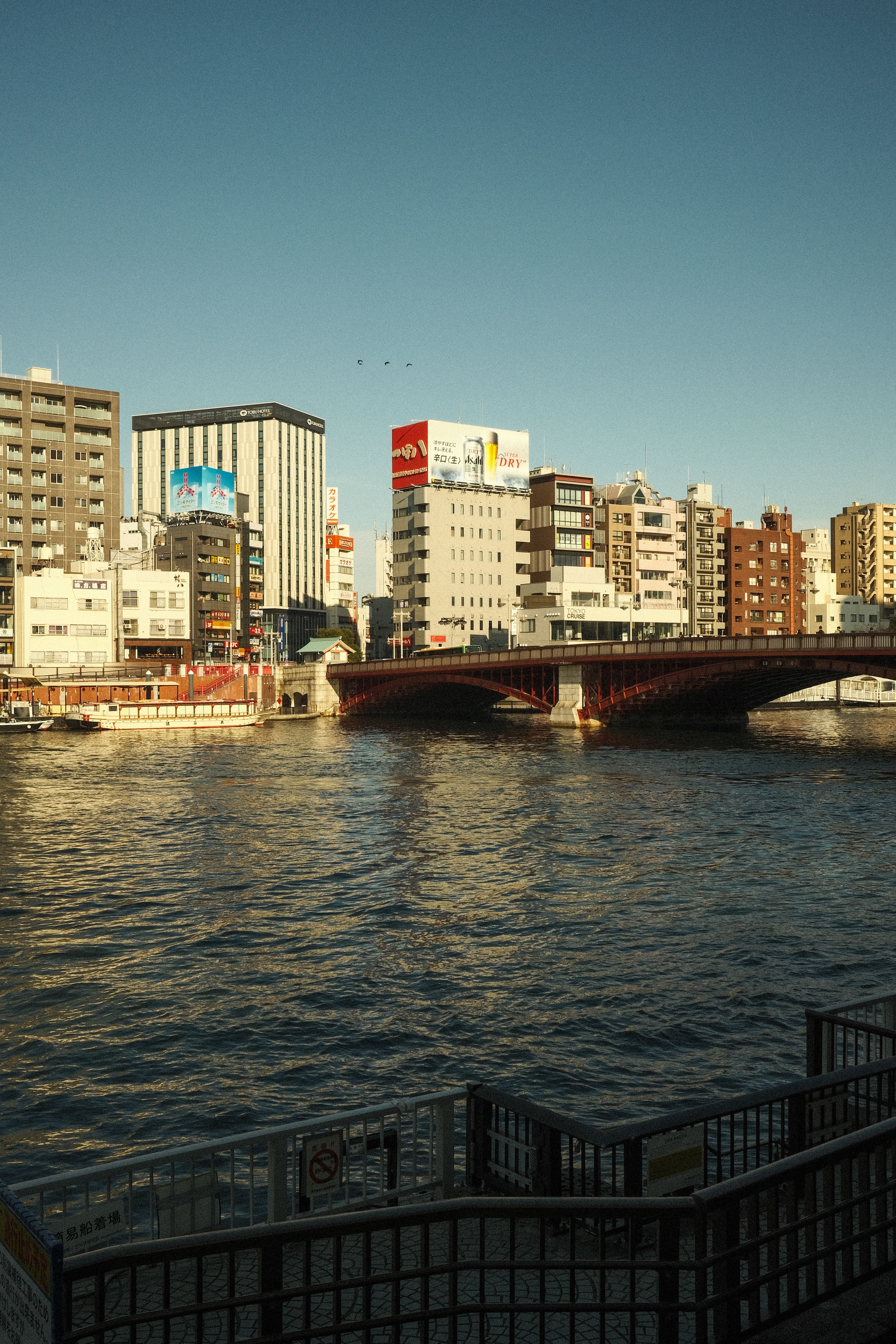 Urban River Scene with City Skyline and Bridge · Free Stock Photo