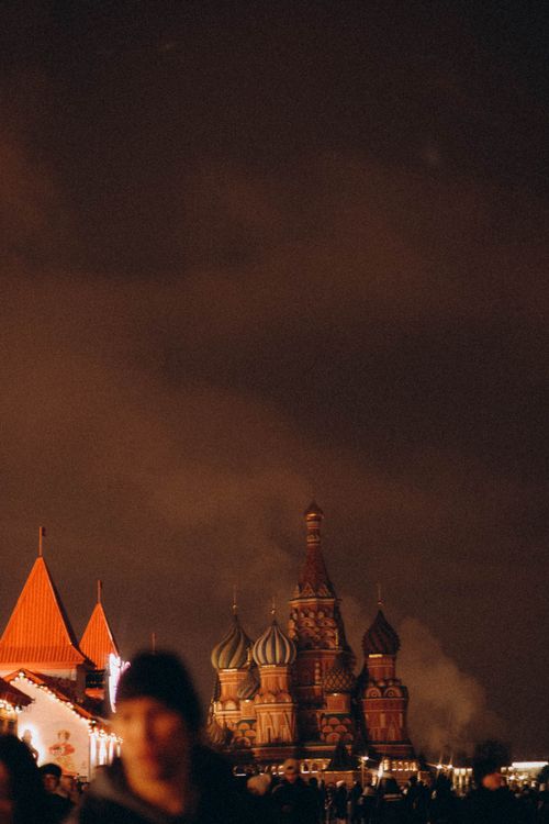Free A serene night view of St. Basil's Cathedral in Moscow with atmospheric lighting and silhouetted crowd. Stock Photo