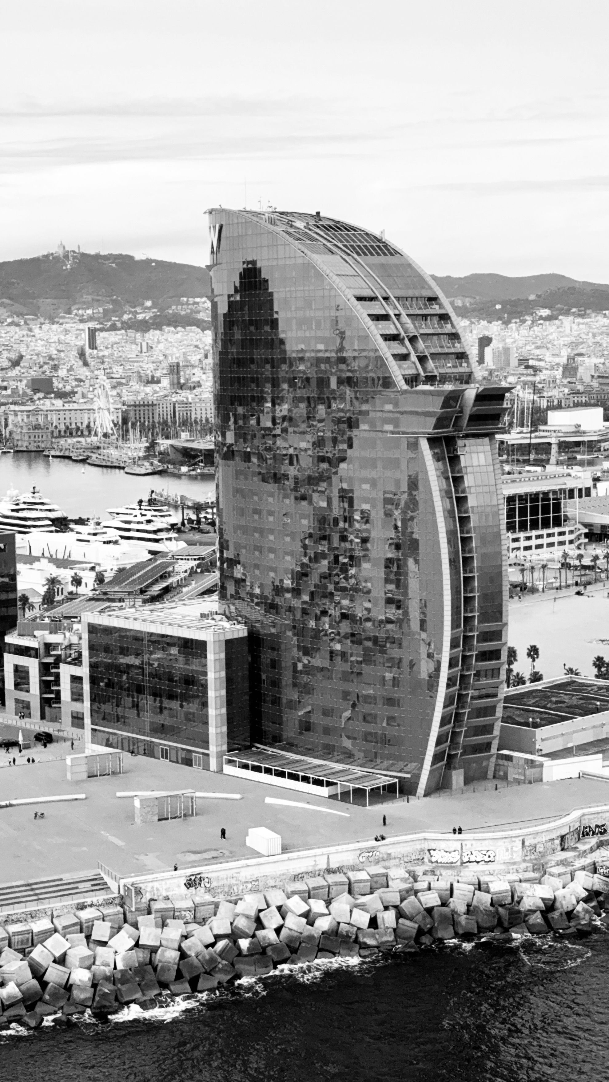 Aerial photograph of the iconic W Barcelona Hotel with the cityscape in black and white.
