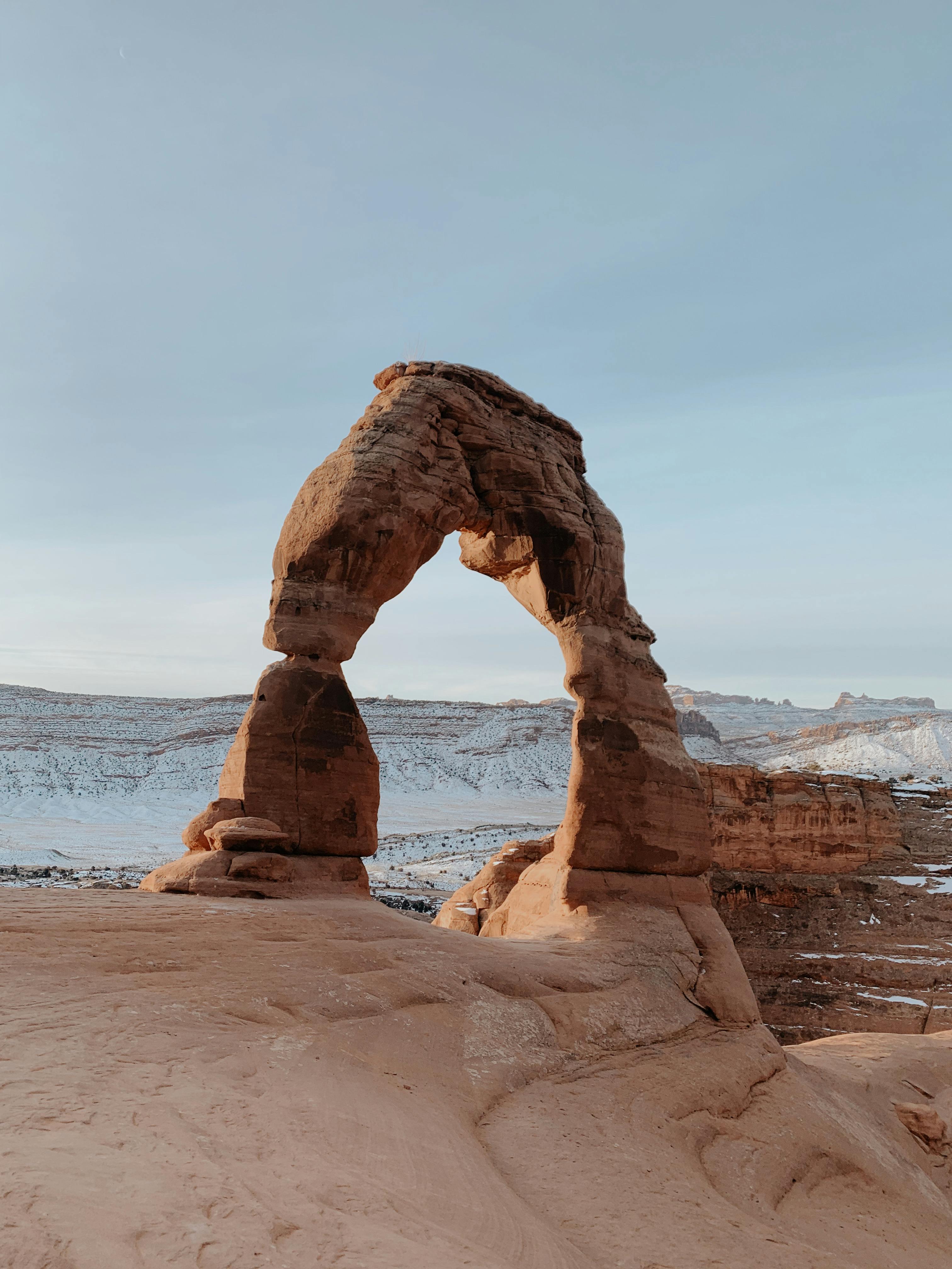 Stunning view of Delicate Arch with snowy backdrop in Arches National Park.