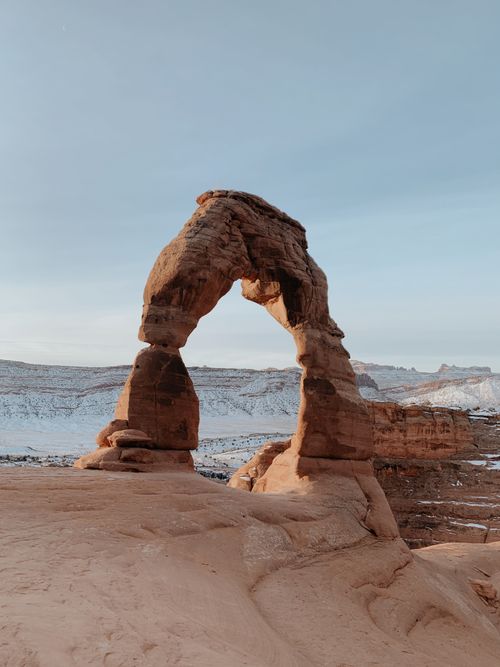 Free Stunning view of Delicate Arch with snowy backdrop in Arches National Park. Stock Photo