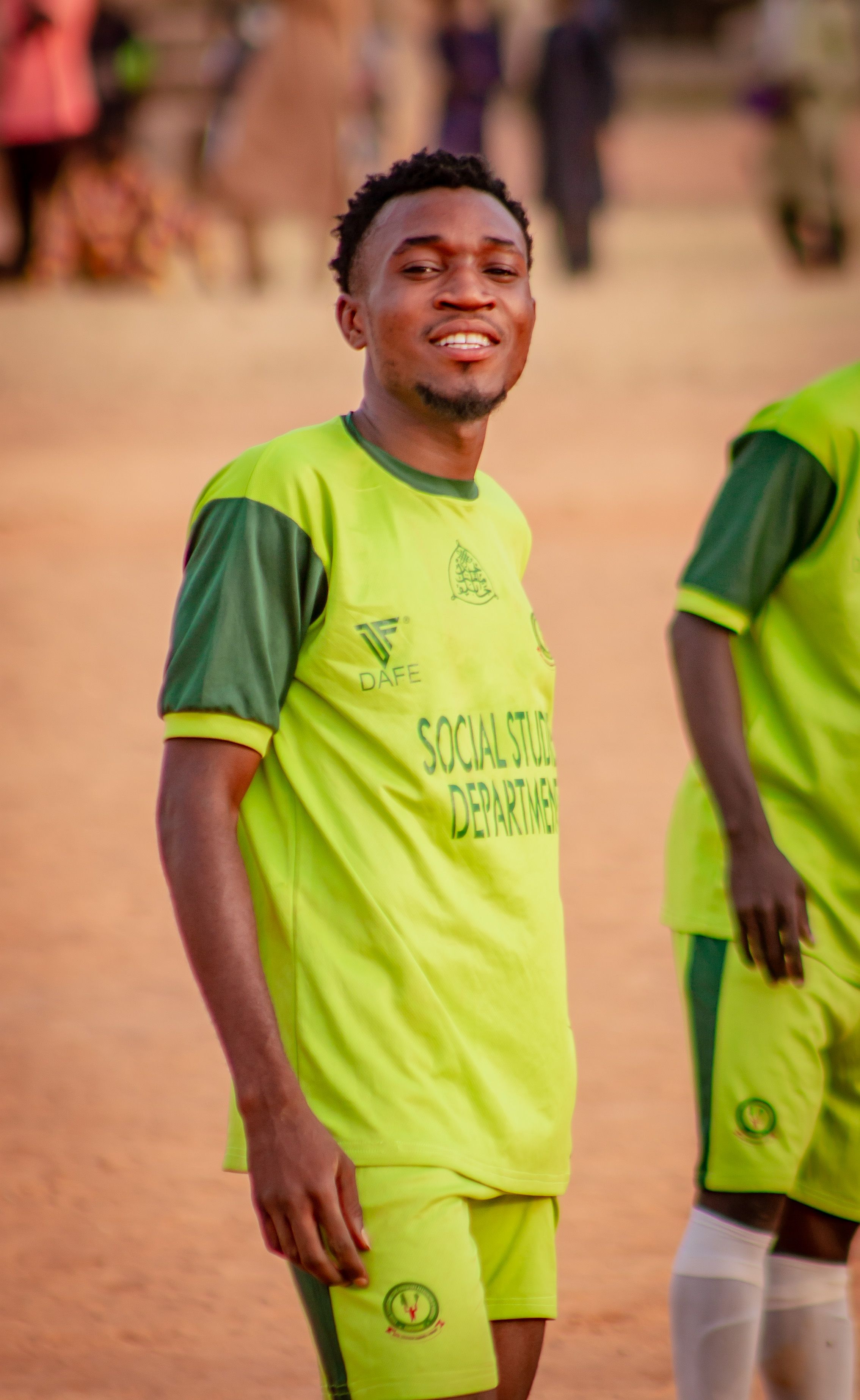 A young male soccer player in vibrant uniform on the field during daytime.