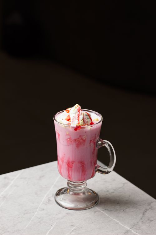 Free Elegant pink whipped cream drink on a marble surface captures sweet indulgence. Stock Photo