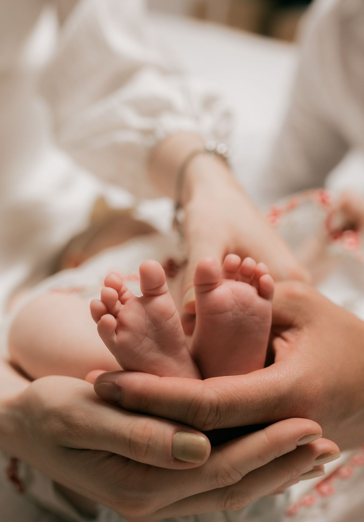 Tiny baby feet held gently in a parent's hands