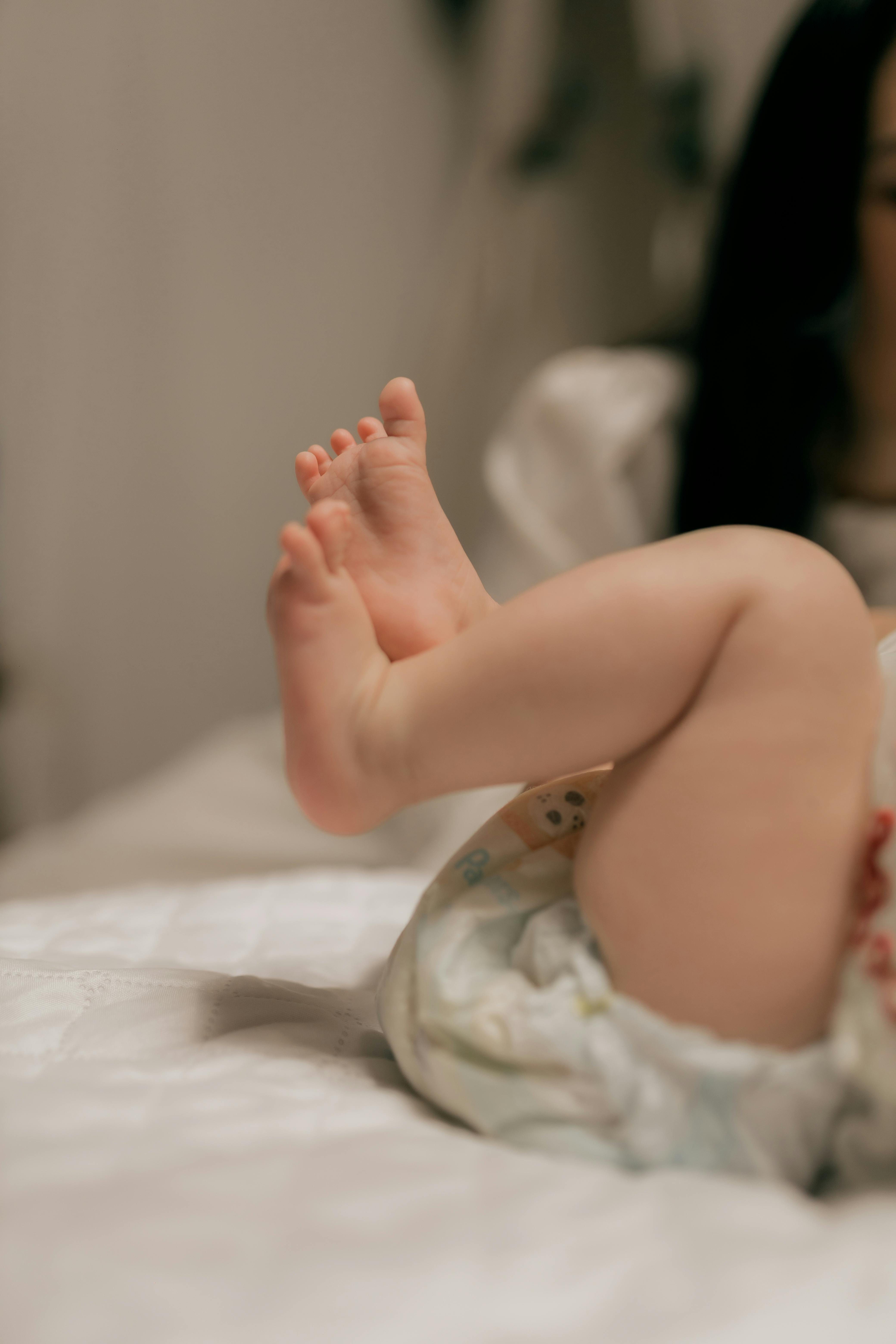 Close-up of a baby's feet on a soft bed, capturing innocence and warmth.
