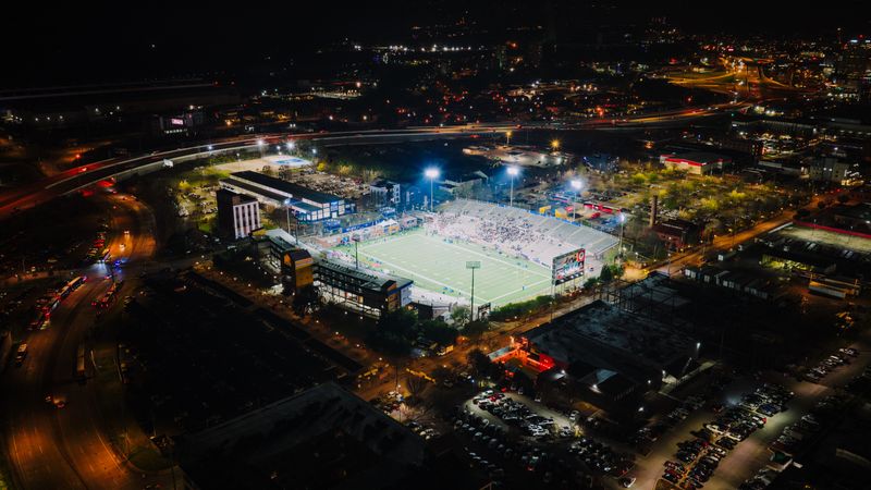 Floodlit football stadium at night, photo by K on Pexels
