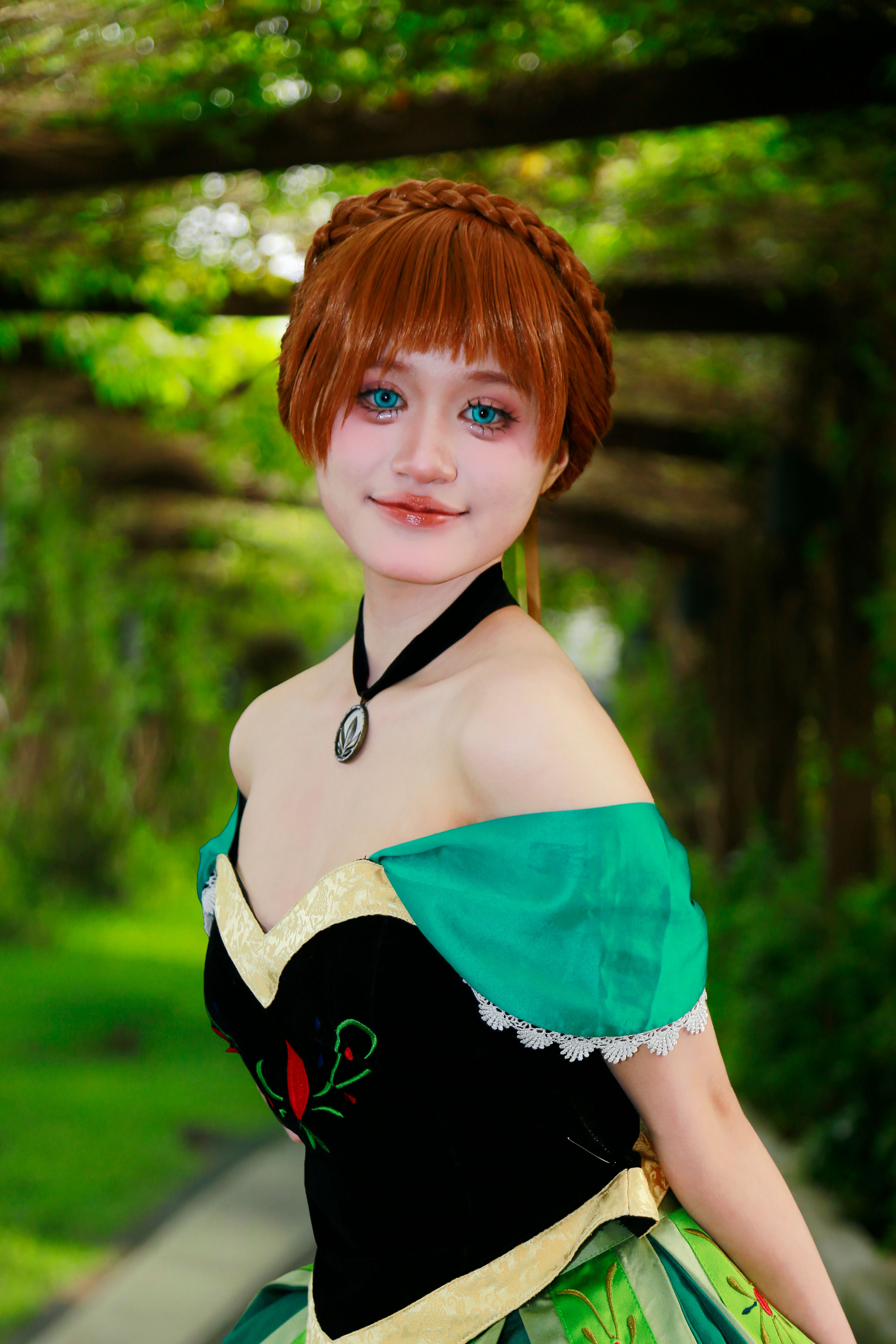 Cosplayer in fantasy costume posing outdoors in a verdant garden.