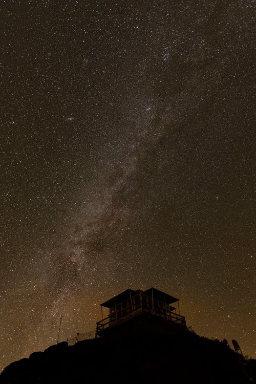 Free Silhouette of a building beneath a breathtaking star-filled Milky Way sky. Perfect for astronomy lovers. Stock Photo