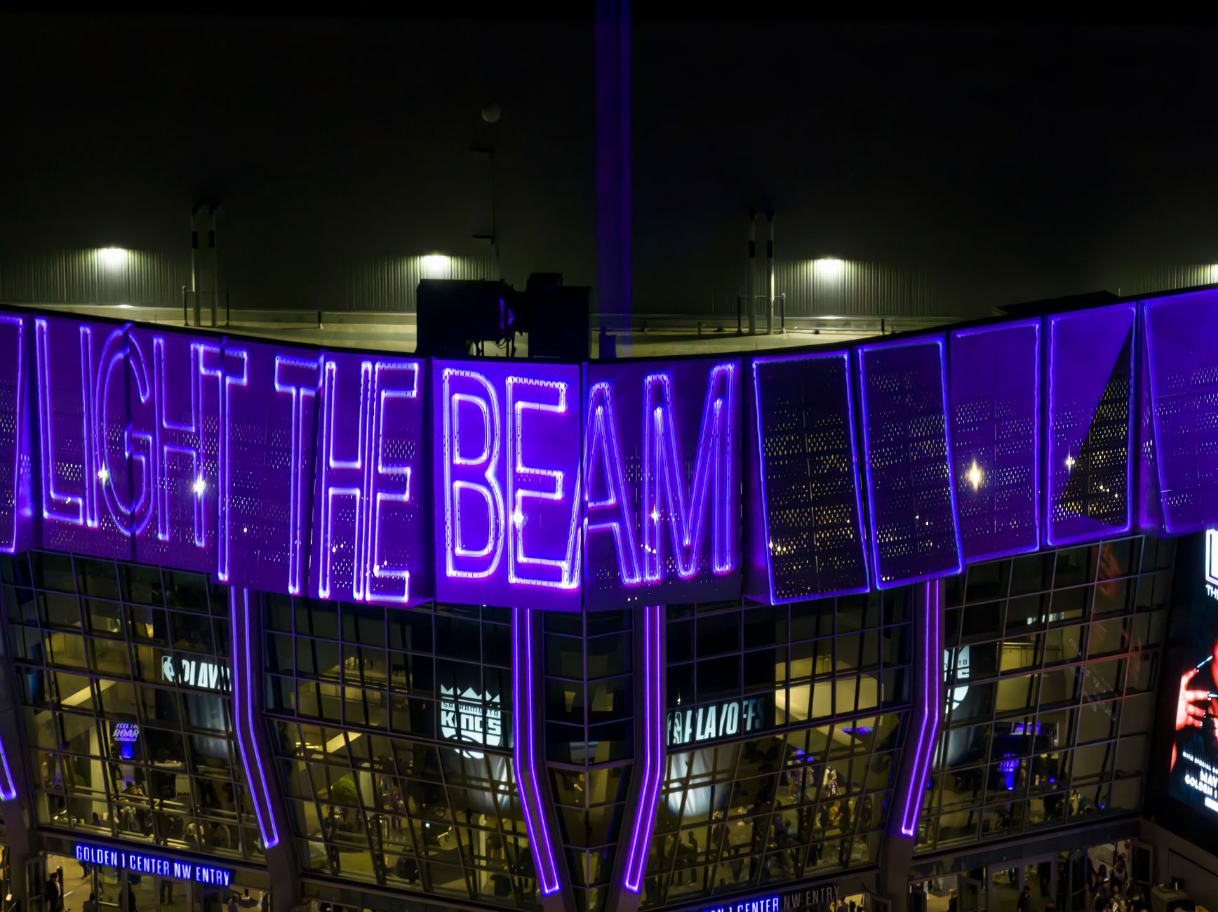 Kansas City stadium glowing at dusk, football supporters gathering beneath colorful World Cup banners