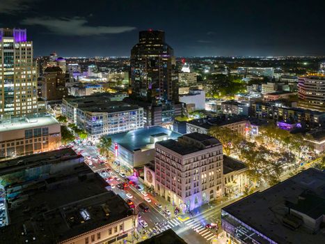 Aerial view of Sacramento's bustling night skyline with illuminated buildings and streets.