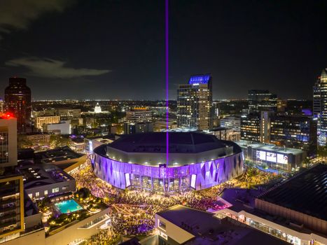 Aerial view of the illuminated Golden 1 Center arena in Sacramento at night, surrounded by city lights.