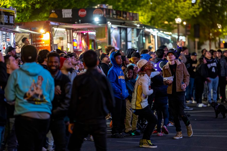 10 Businesses You Can Start With $100K In Business Capital 1 A lively crowd gathers around vibrant food trucks at night, enjoying a bustling street food experience.