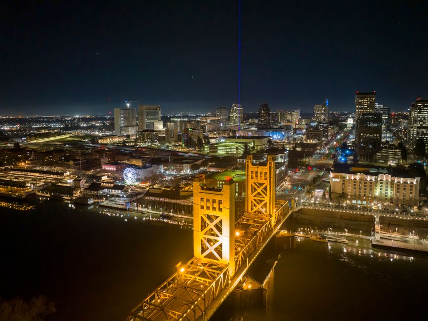 Aerial view of Sacramento's Tower Bridge and cityscape beautifully illuminated at night.