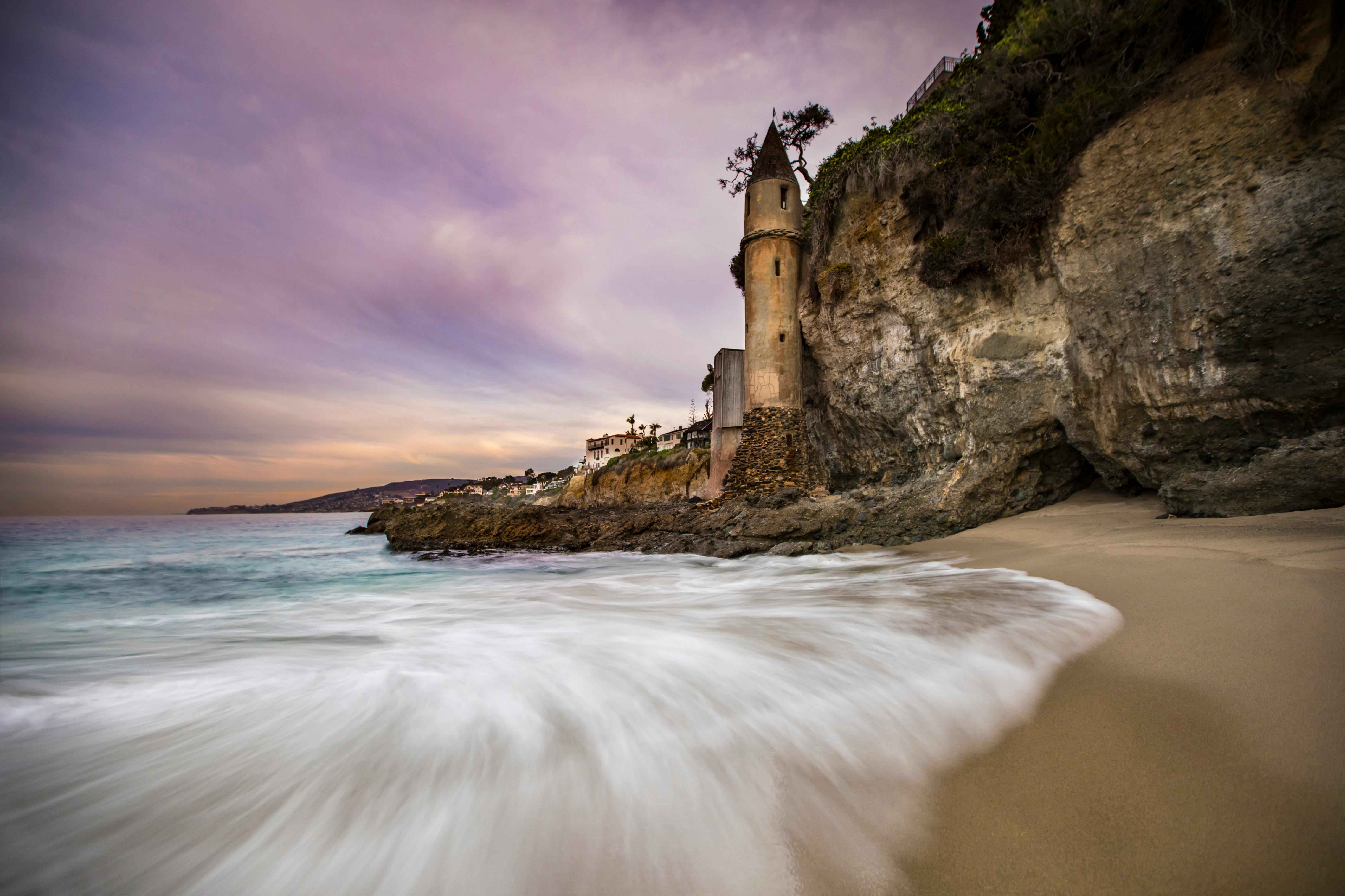 Enchanting sunset at Victoria Beach with iconic pirate tower and gentle waves.