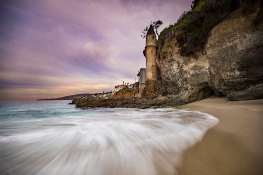 Enchanting sunset at Victoria Beach with iconic pirate tower and gentle waves.