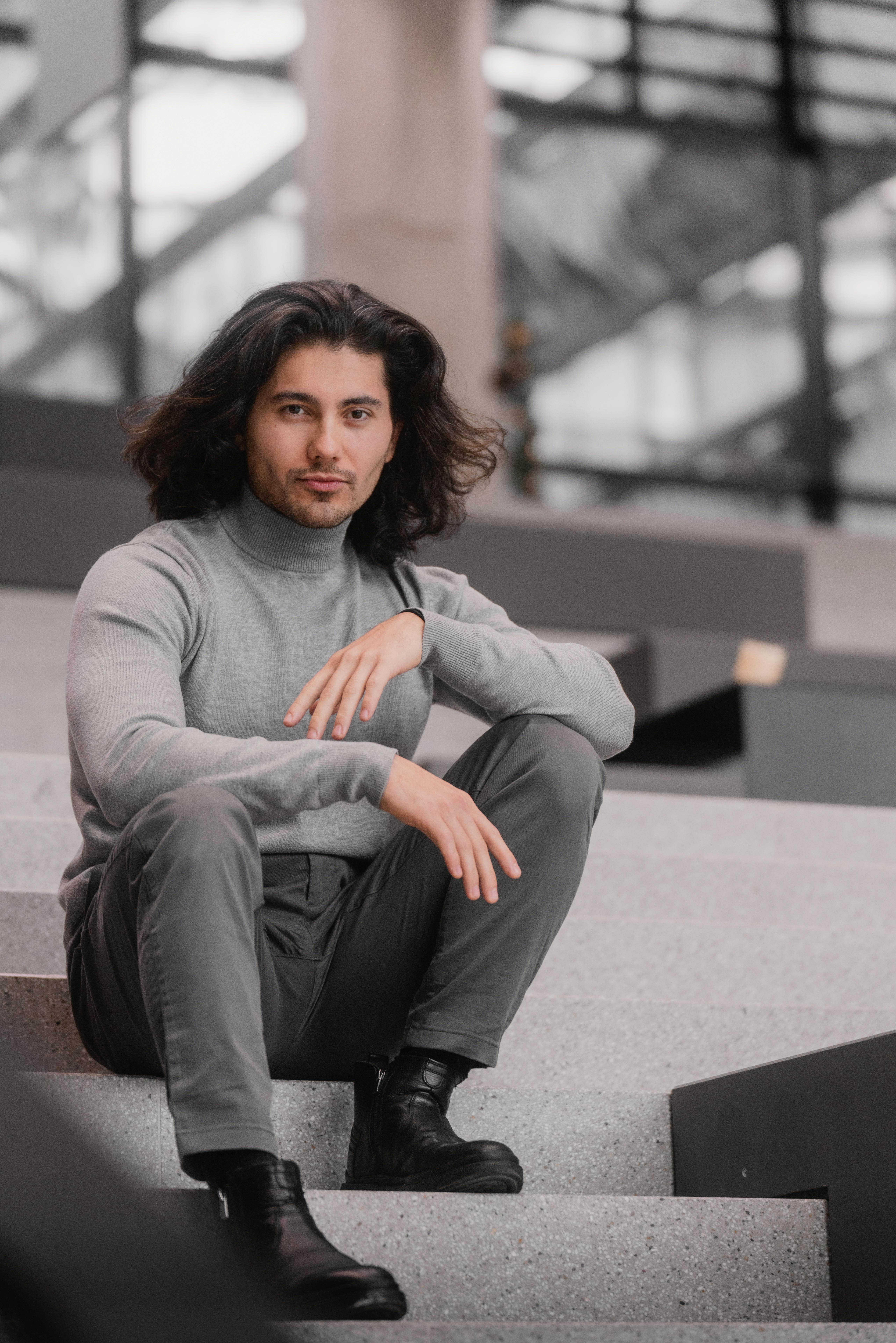 무료 현대적인 도시 풍경 속, 비엔나의 계단에 앉아 있는 회색 옷차림의 세련된 젊은이. 스톡 사진