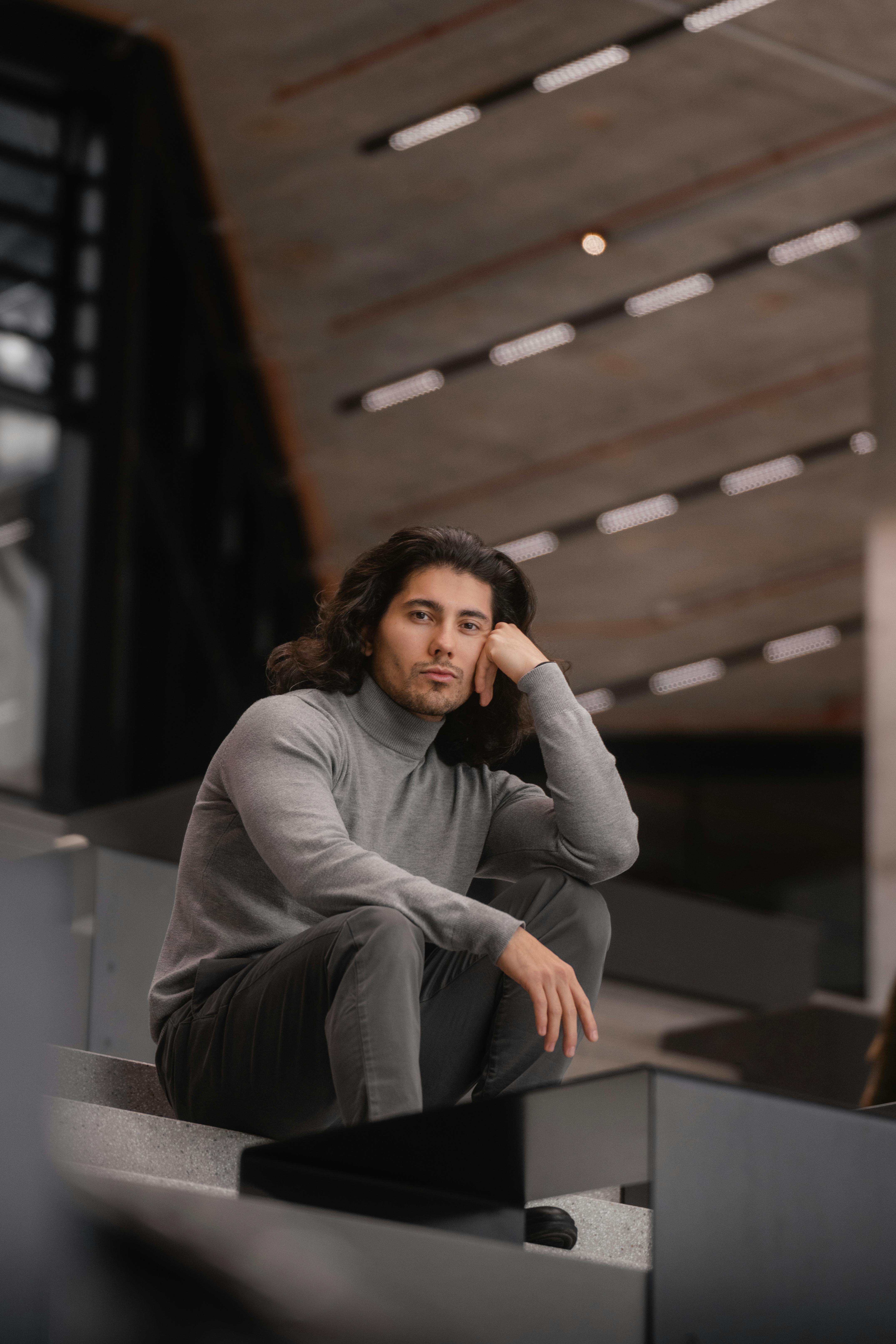 Zadarmo Štýlový portrét muža sediaceho v interiéri vo Viedni, ktorý predvádza moderný módny vzhľad. Fotka z fotobanky