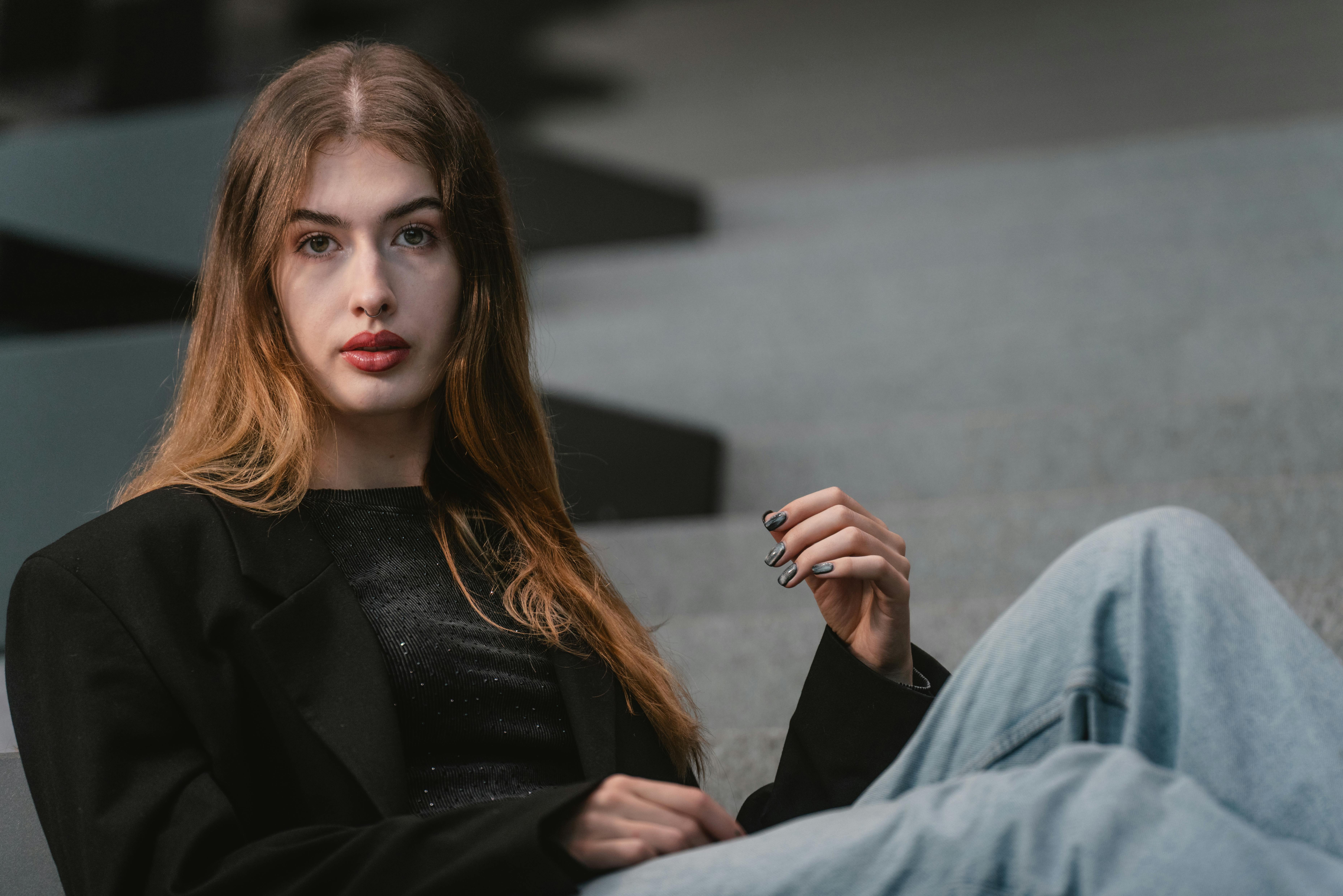 bezplatná Portrét ženy ve stylovém moderním oblečení sedící na schodech, vyzařující ležérní eleganci. Základová fotografie