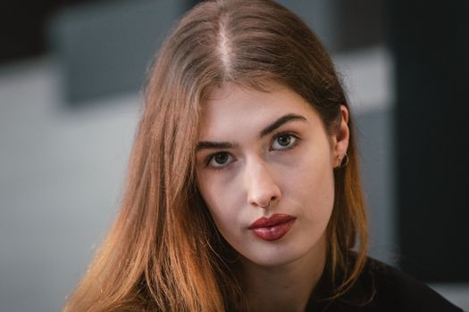 A striking portrait of a young woman with long hair and red lips, exuding modern elegance.